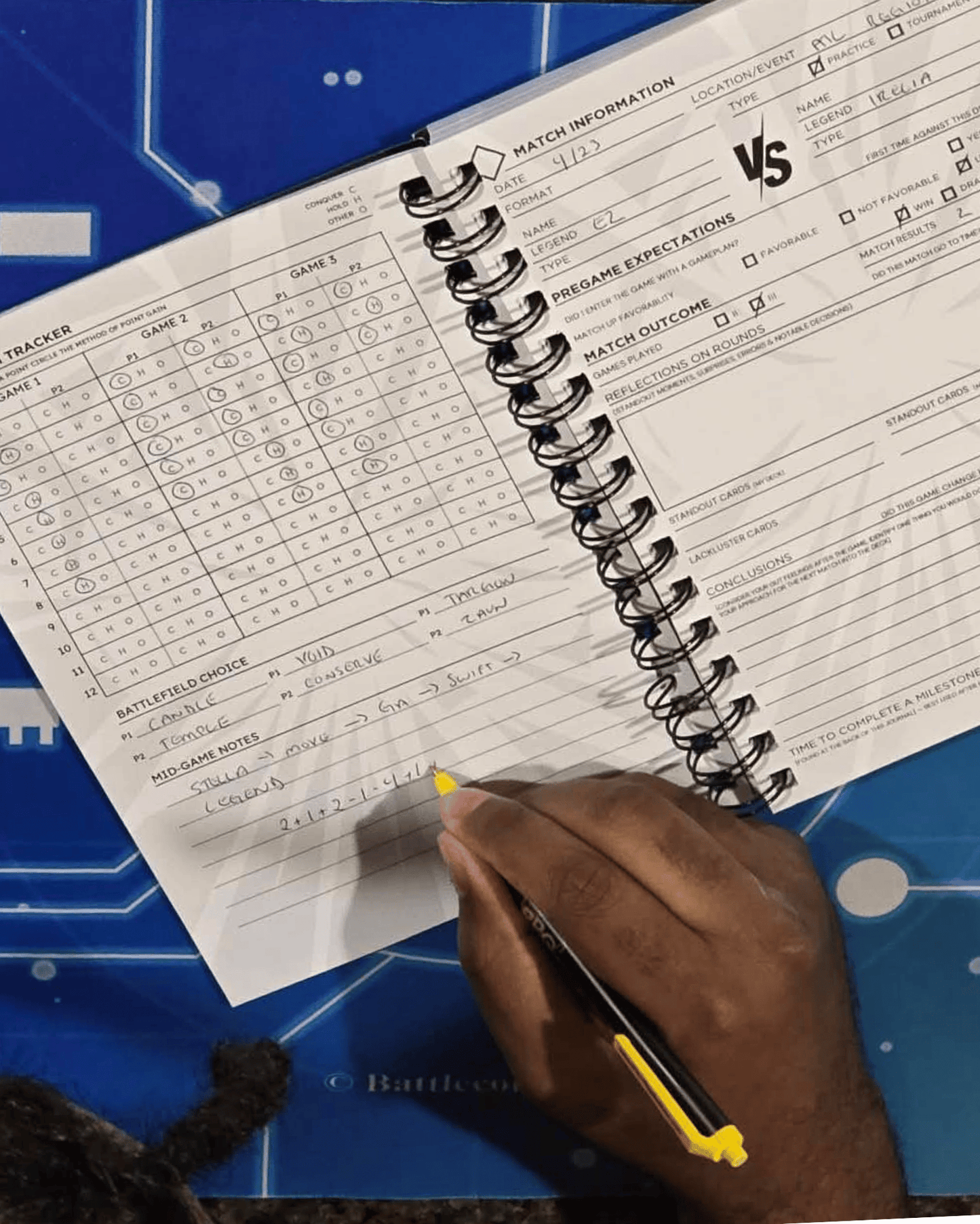 Writing in Codex Journal Riftbound Battlecore Edition during gameplay, showing match tracking and note-taking system for competitive TCG improvement